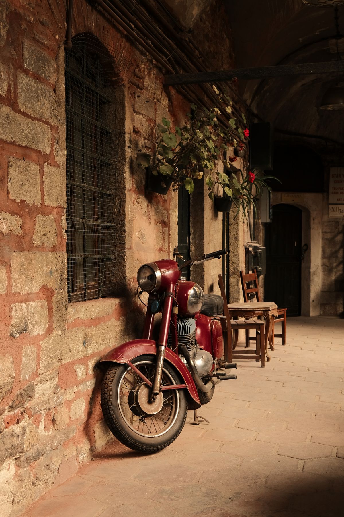 Altes Motorrad, lange an einer Mauer abgestellt
