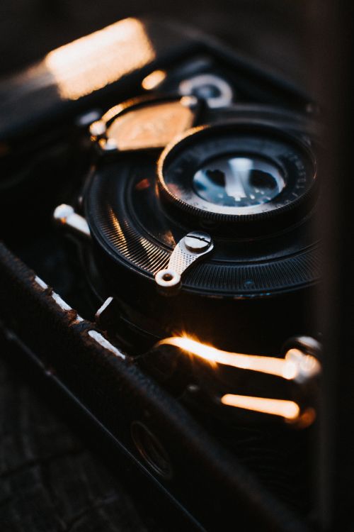 Free Close-up of a vintage camera lens with warm sunlight reflections, emphasizing its classic design. Stock Photo