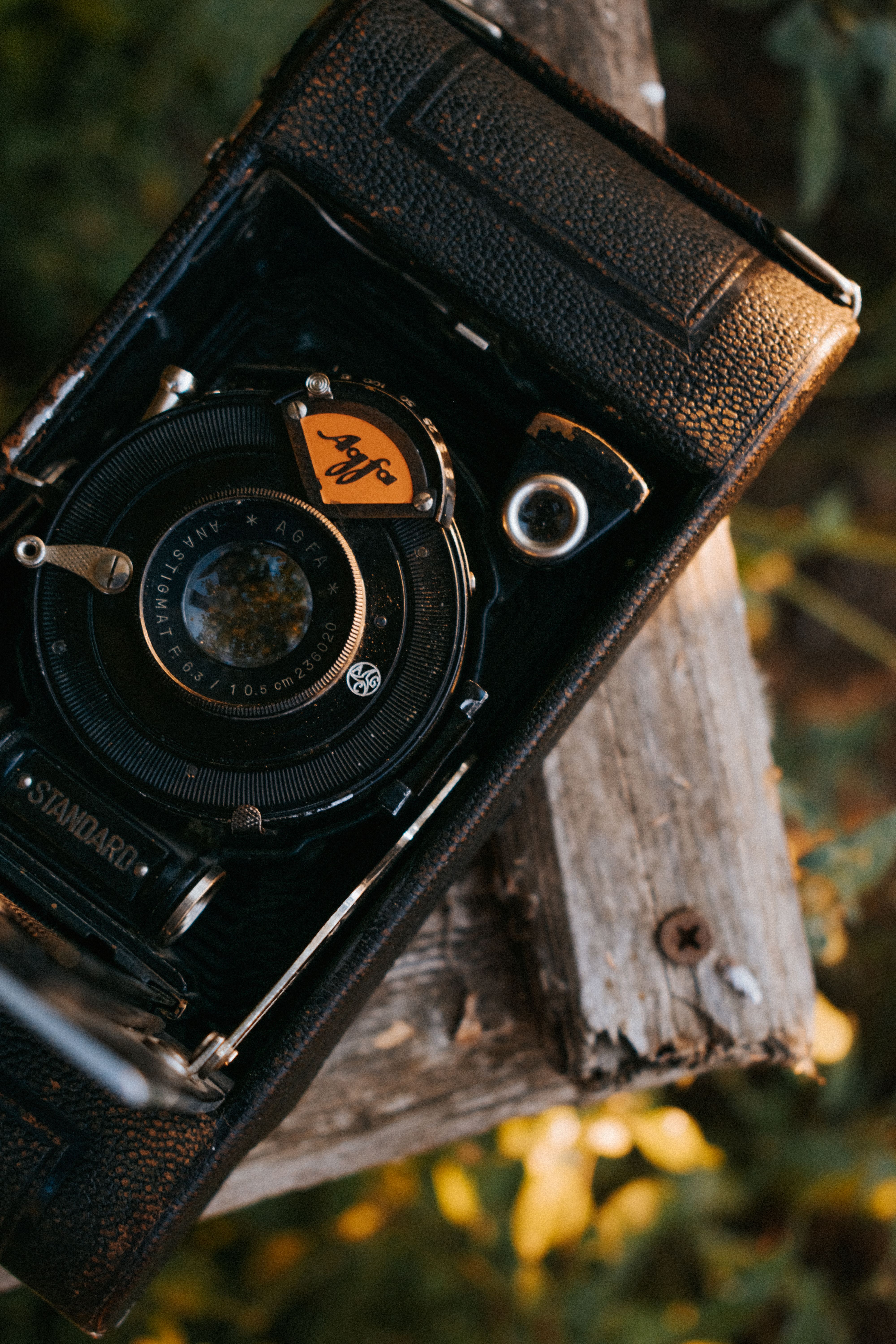 Detailed shot of a classic vintage analog camera outdoors on a wooden surface.