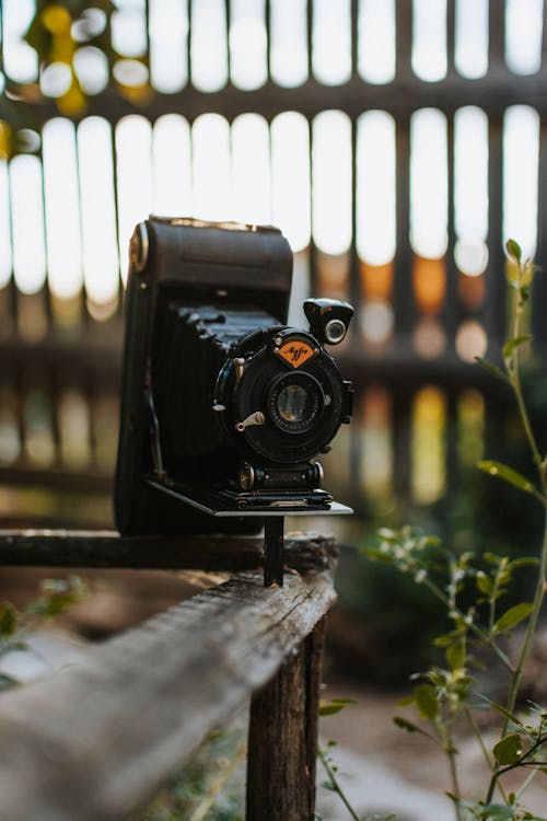 Free Black Dslr Camera on Brown Wooden Fence Stock Photo