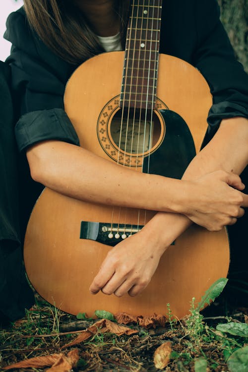 Person Embracing Acoustic Guitar