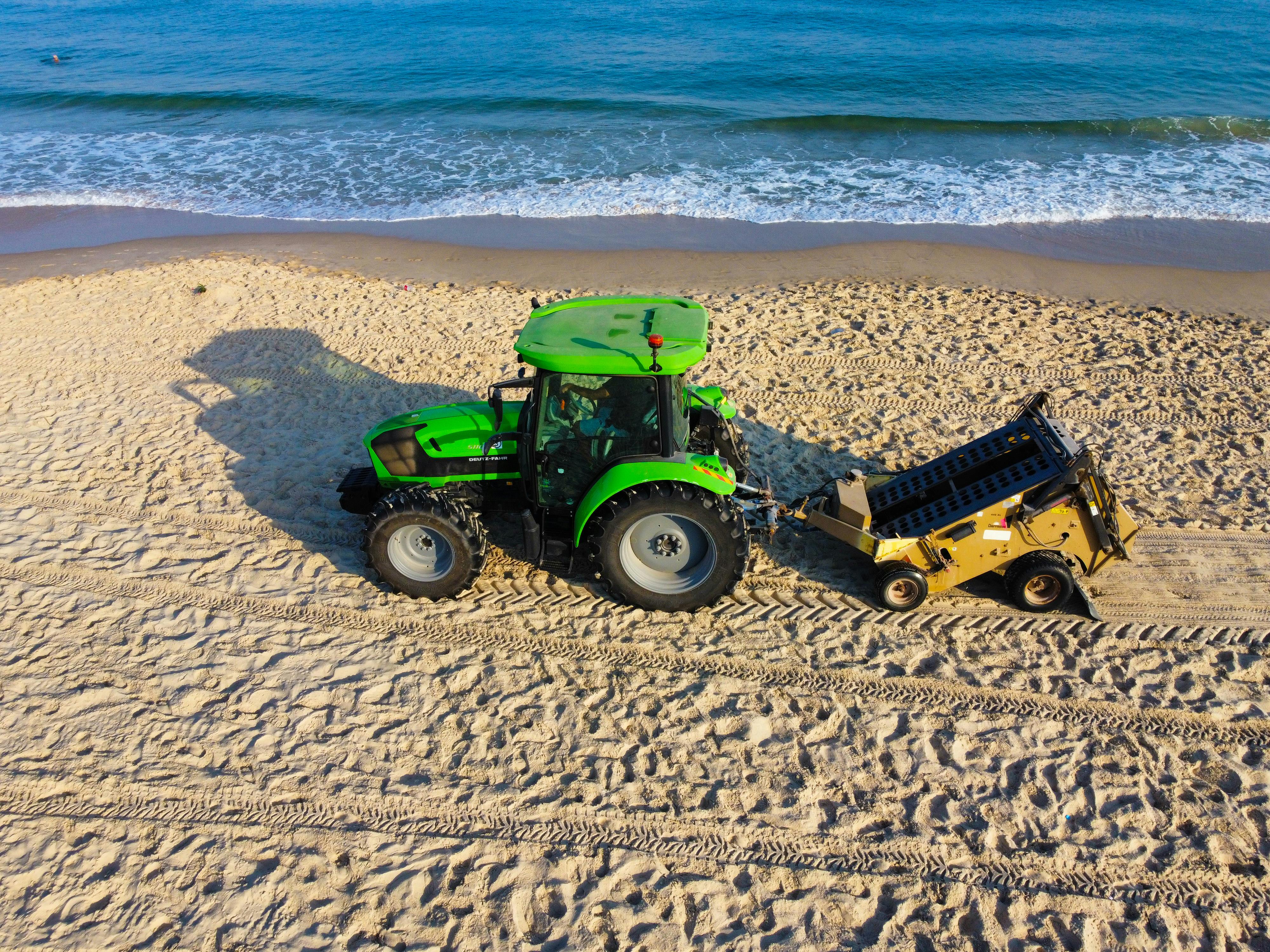 A Green Tractor on the Beach · Free Stock Photo