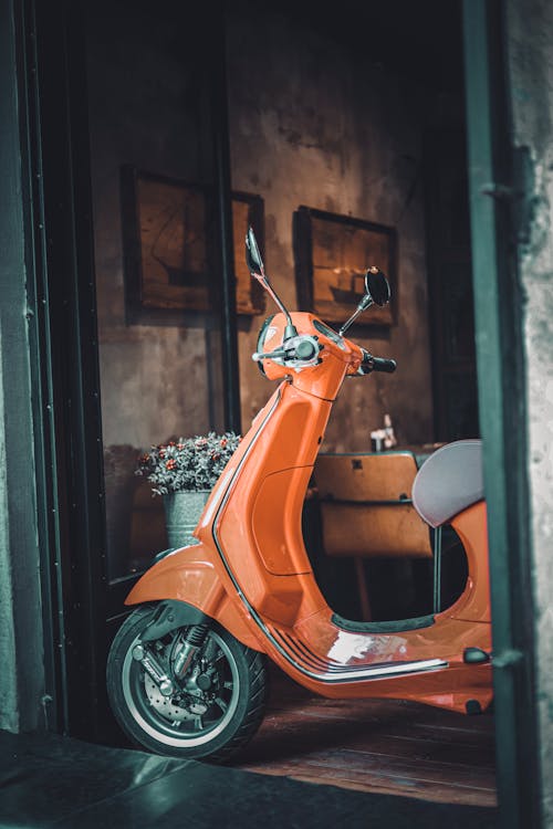 An Orange Scooter Standing Inside a House 