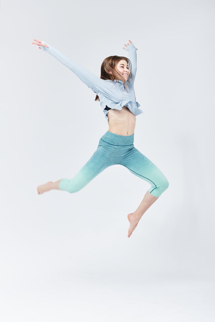 A Woman In Blue Long Sleeves Jumping