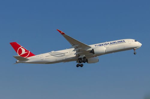 Free Airbus A350 of Turkish Airlines flying against a blue sky. Stock Photo