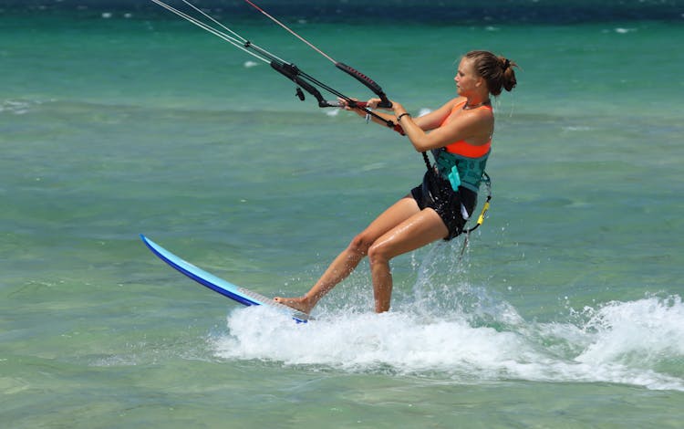 Woman Kitesurfing On Water