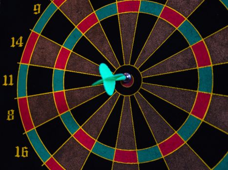 A vibrant close-up of a dart hitting the bullseye on a colorful dartboard, showcasing precision.