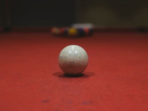 Free A detailed shot of a billiard ball on a red pool table surface with blurred background. Stock Photo