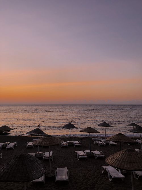 Free Relaxing sunset view over Yalova beach with umbrellas and loungers. Perfect for scenic getaways. Stock Photo