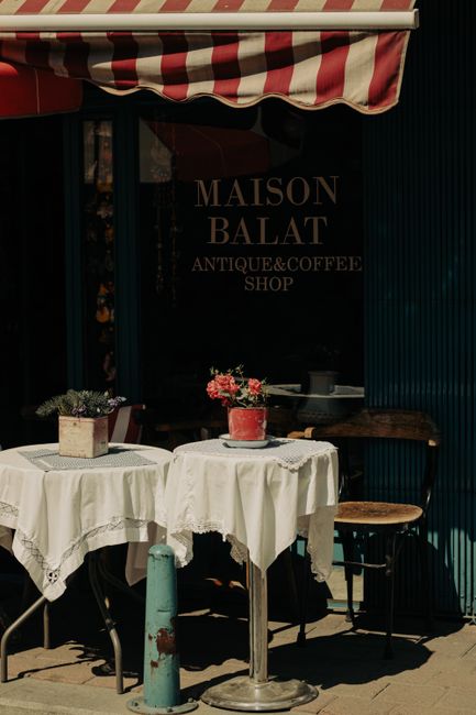 Cozy outdoor café scene with antique decor and floral accents.
