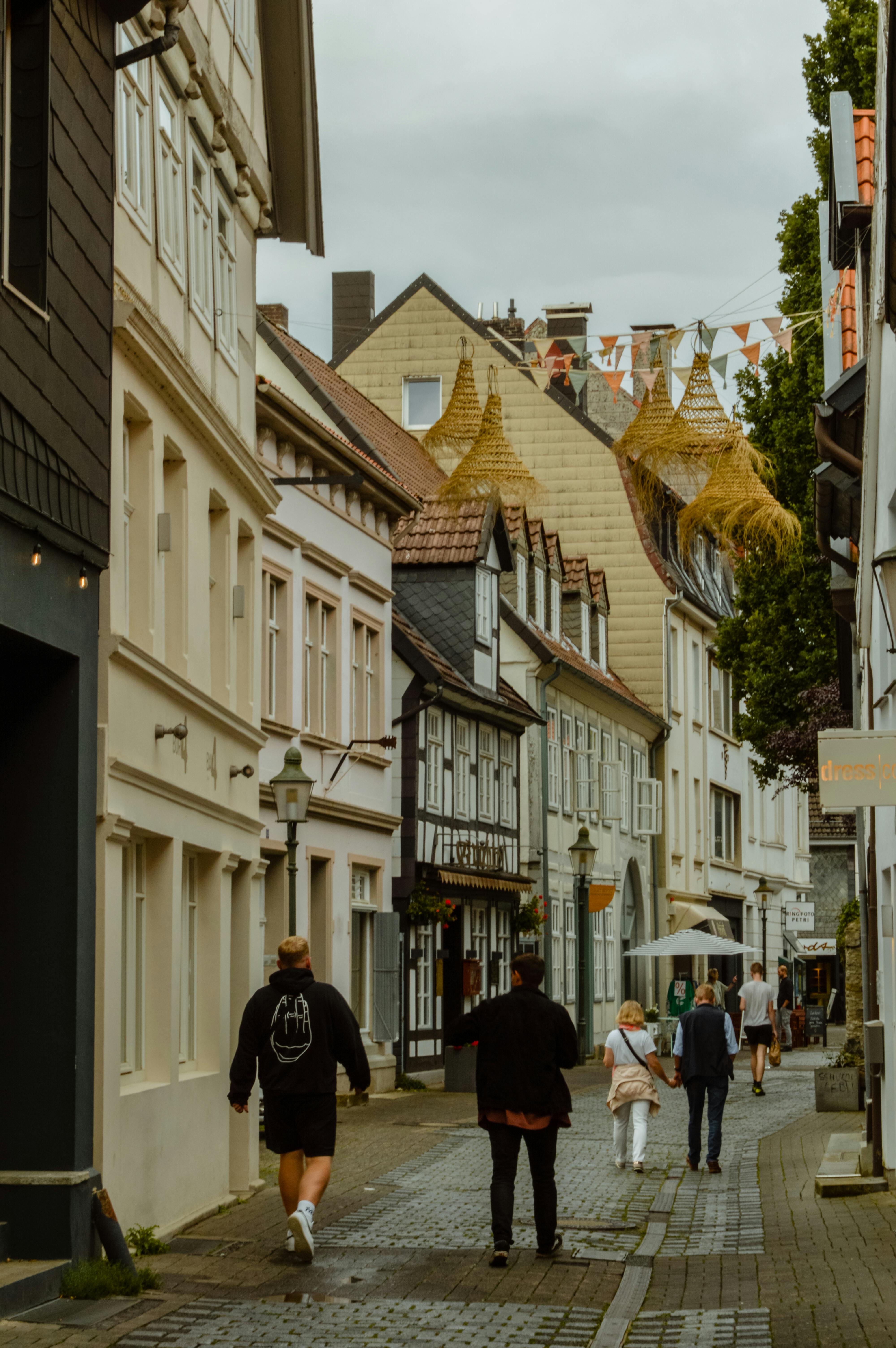 A peaceful European street with historical buildings and people walking under an overcast sky.