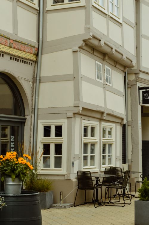 Free Outdoor view of a quaint half-timbered building with outdoor seating and floral decor. Stock Photo