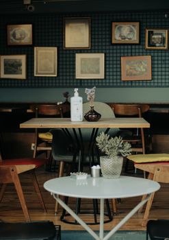 Inviting café interior featuring wooden tables, chairs, and artistic wall frames.