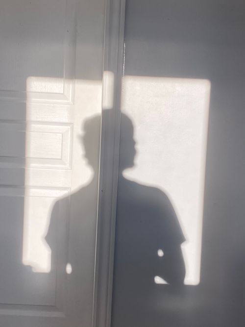 Free A shadow of a person on a bright wall, creating an artistic silhouette. Stock Photo