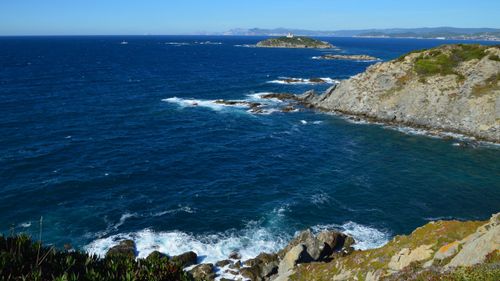 Free Breathtaking view of a rocky shoreline and deep blue sea waves on a sunny day. Stock Photo