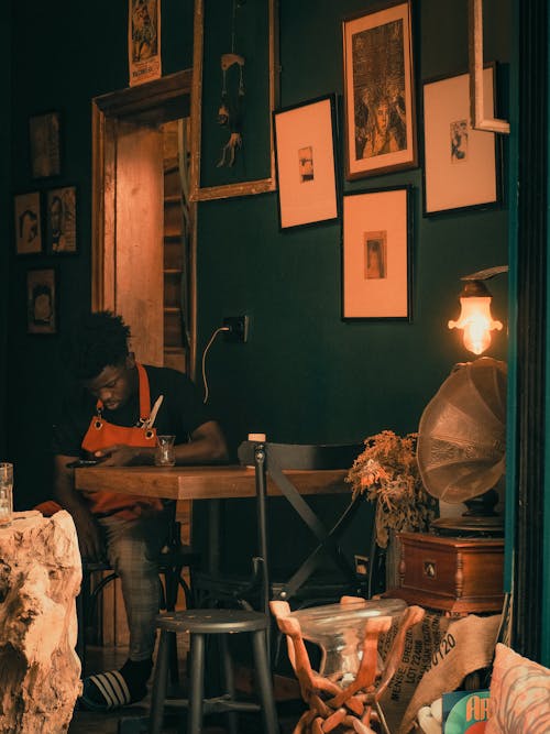 Man Sitting on Chair Looking at His Cellphone