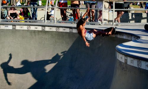 Free Woman skateboarder executing a trick at a Los Angeles skatepark during the day. Stock Photo