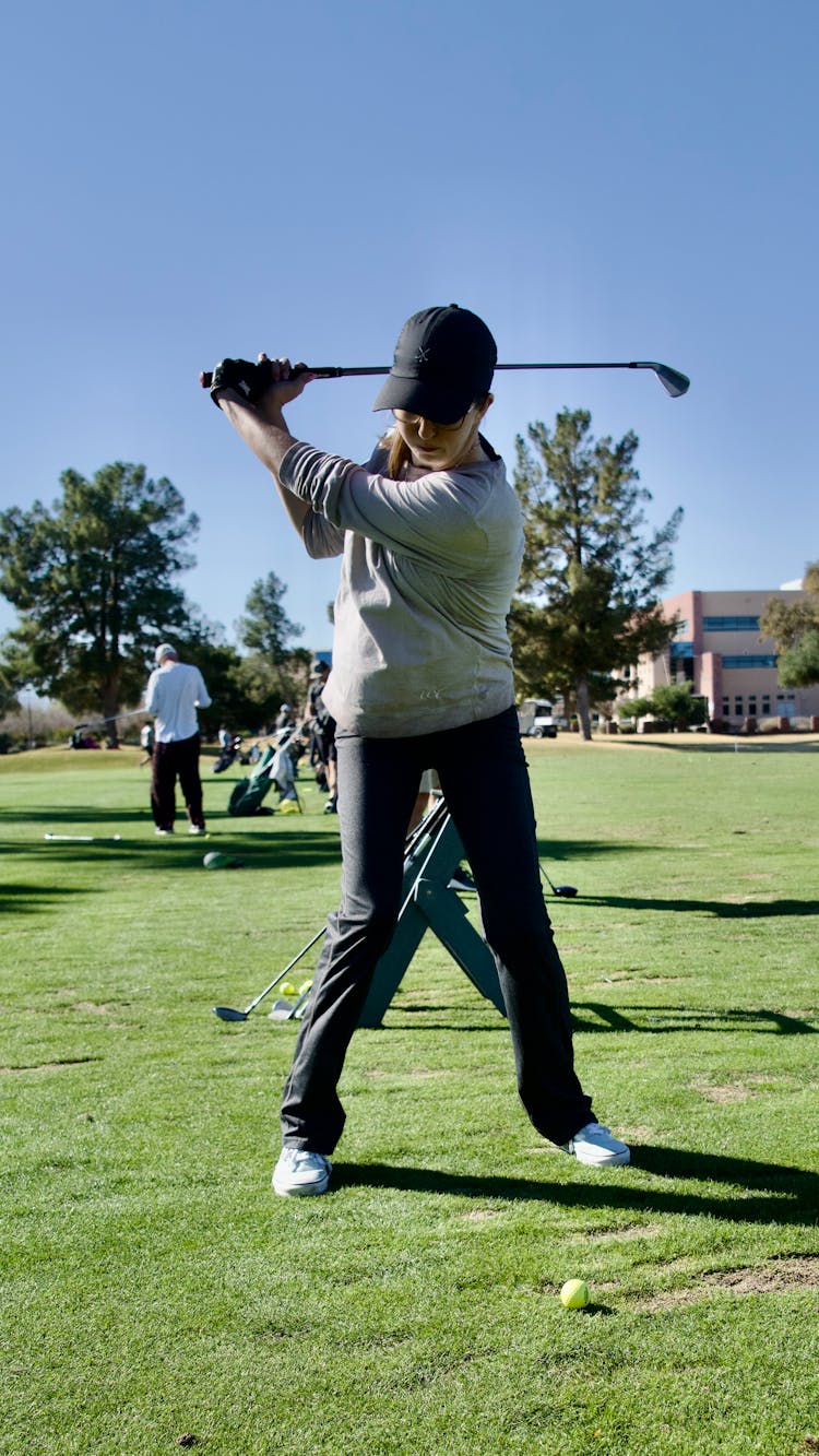 Woman Playing Golf On Golf Field