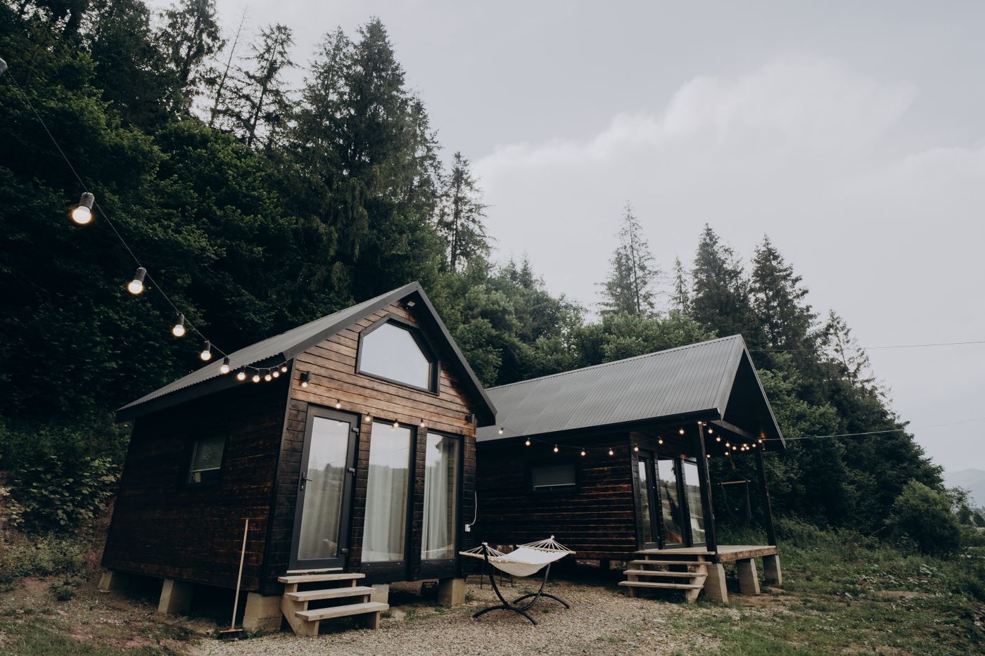 college student tiny home village â€” modern cottages with bike racks, string lights, students walking between units
