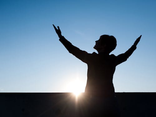 Silhouette of a Person Raising His Hands