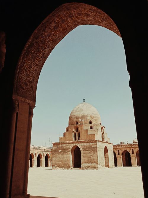 Free Capture of the Mosque of Ibn Tulun showcasing its iconic dome and arches in Cairo, Egypt. Stock Photo