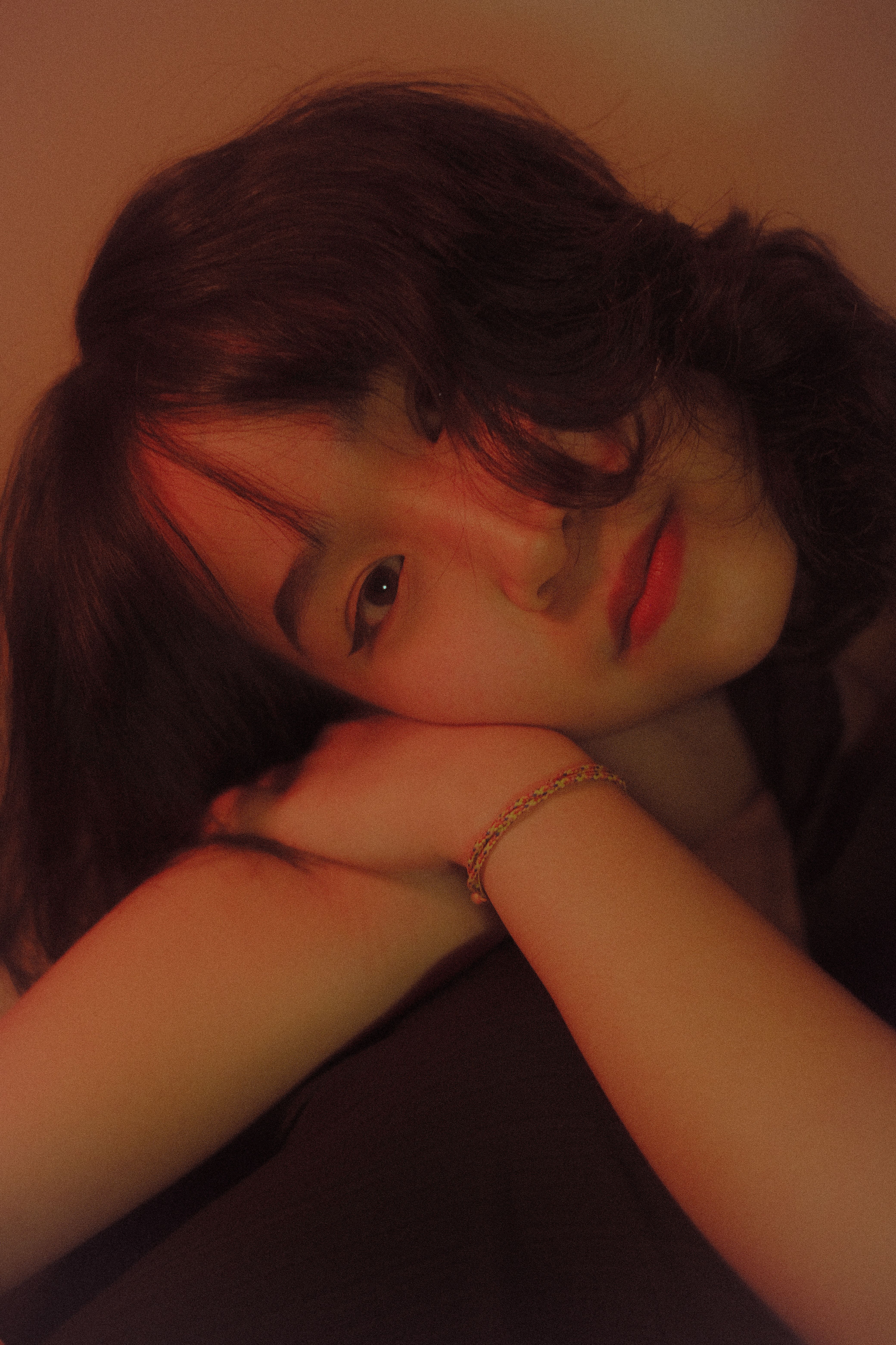 Soft, warm portrait of a woman reclining with subtle lighting.