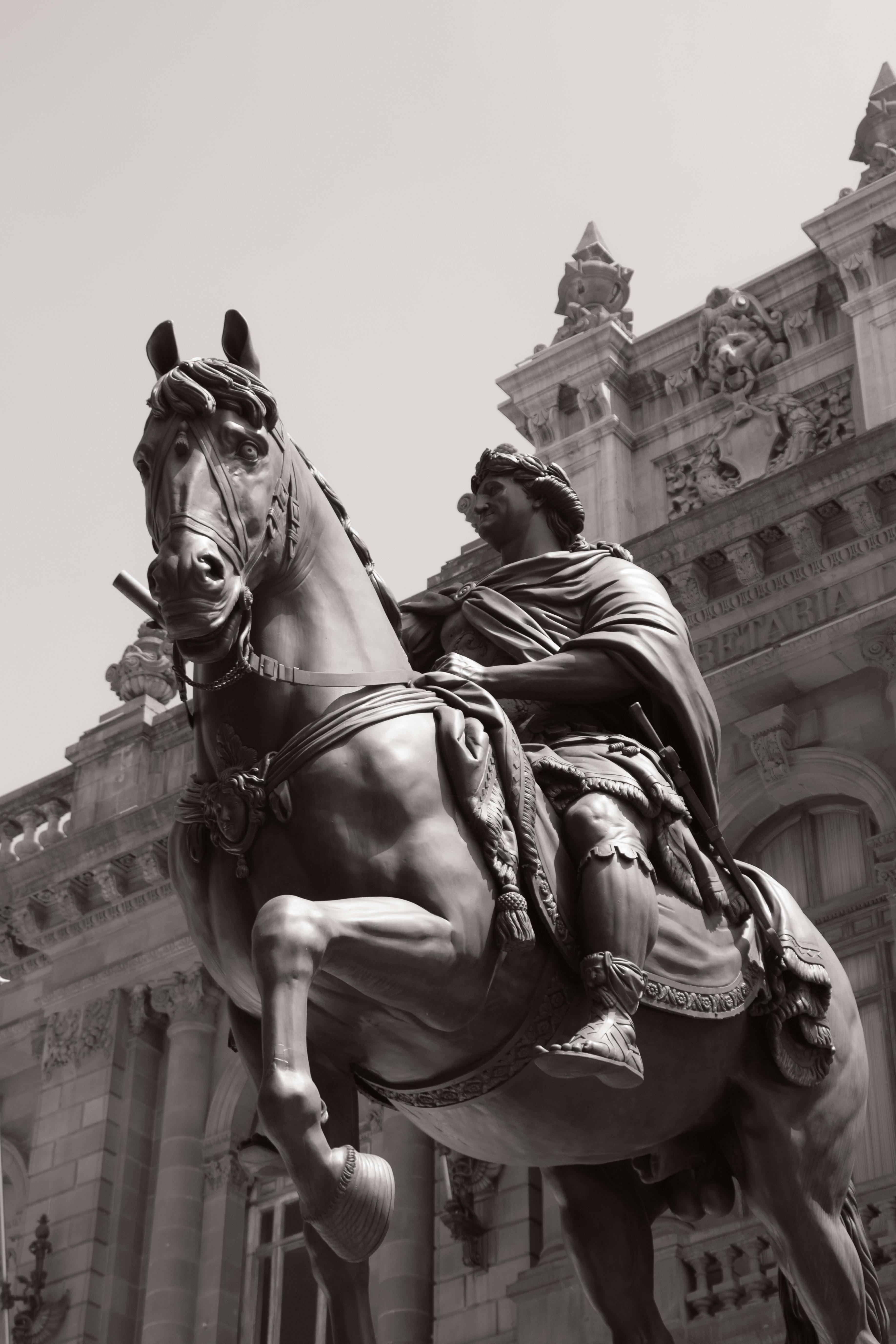 Statue of a Man Riding Horse Near Building in Grayscale Photo · Free ...