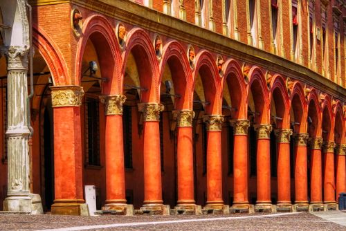 Free A striking image of a historic arched colonnade in Italy, showcasing vibrant architecture. Stock Photo