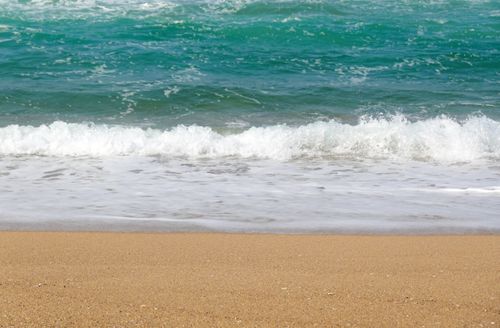Free Calm ocean waves gently crash onto a sandy beach, capturing the essence of tranquility. Stock Photo