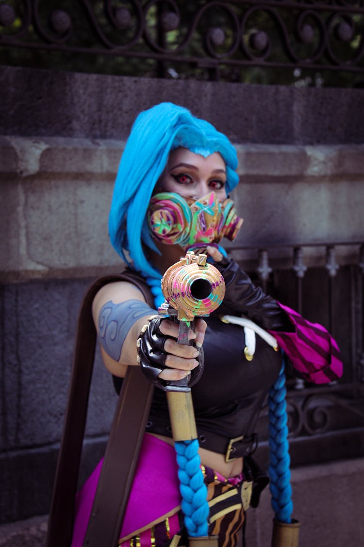 A Woman With Blue Hair Holding A Toy Gun