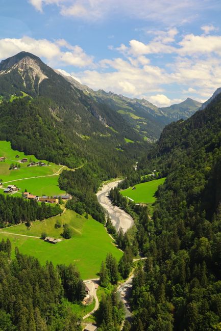Breathtaking aerial view of a rural mountainous landscape with lush greenery and flowing river.