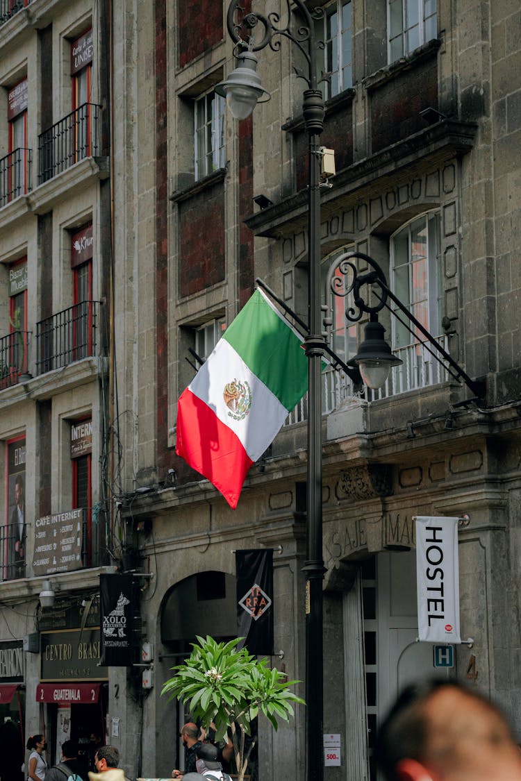 Mexican Flag Beside A Concrete Building