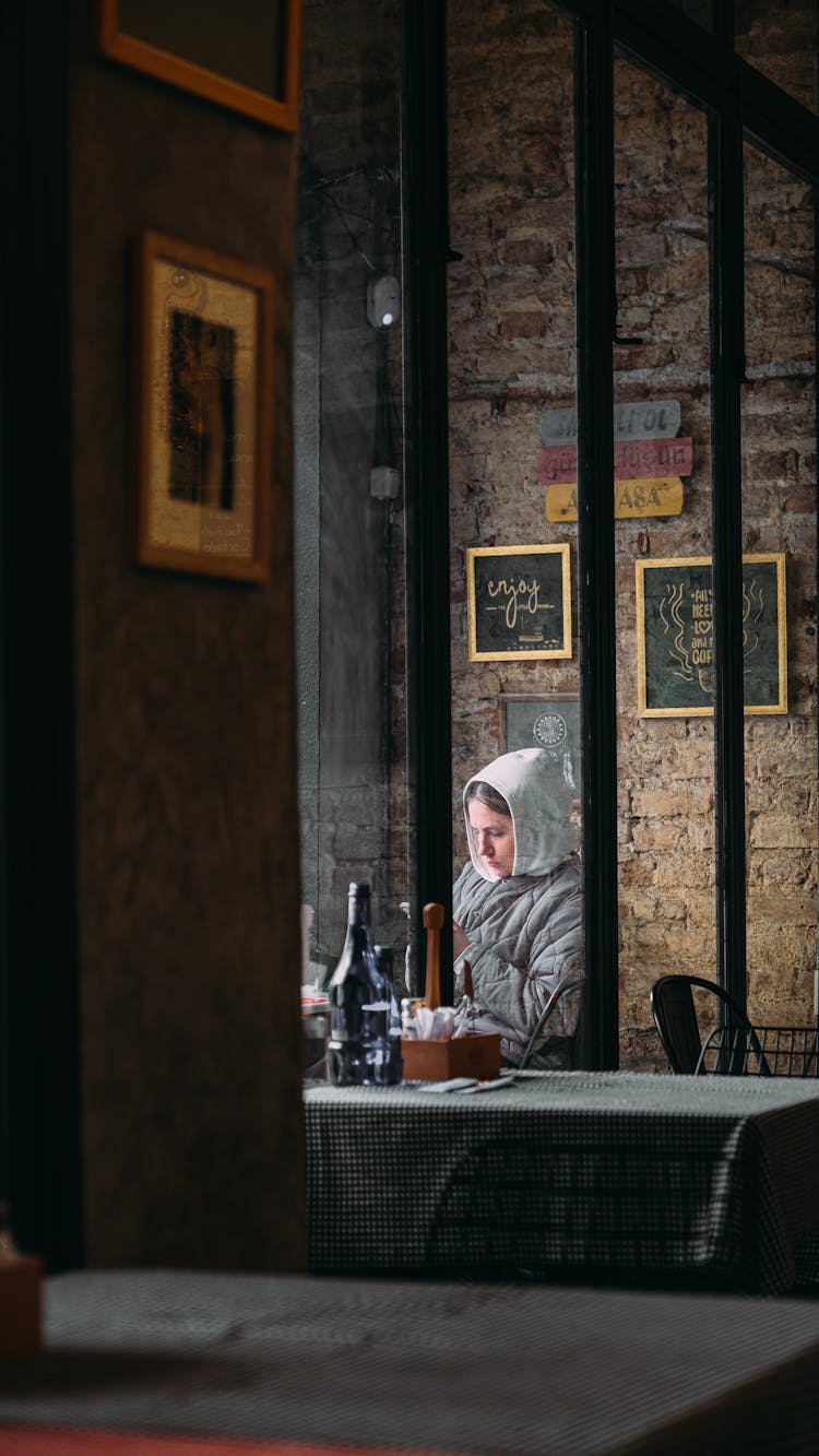 Woman In Hoodie Sitting In Bar