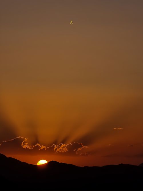 Free Beautiful sunset over mountains with dramatic sun rays and vibrant sky. Stock Photo