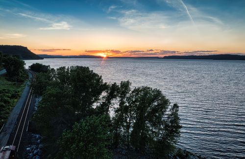 Free Scenic sunset over Lake Pepin with lush trees and railway in Lake City, MN. Stock Photo
