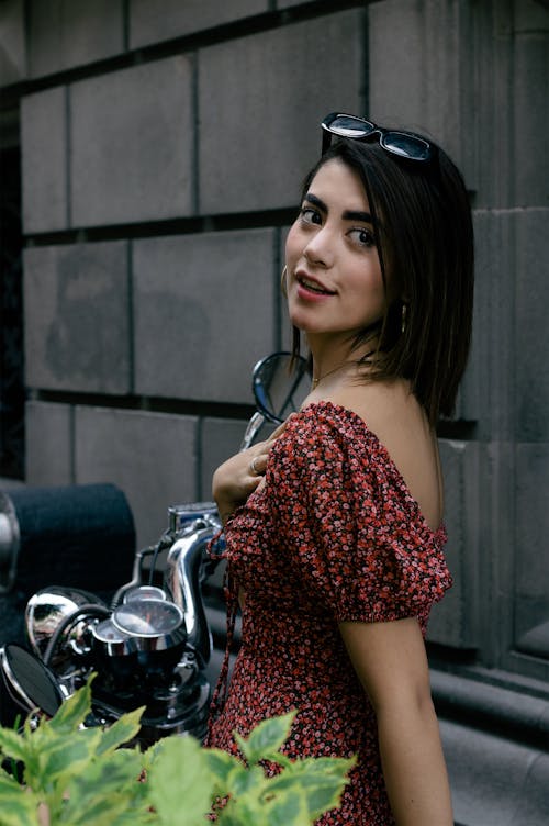 Woman in Floral Off Shoulder Dress Sitting on a Motorcycle