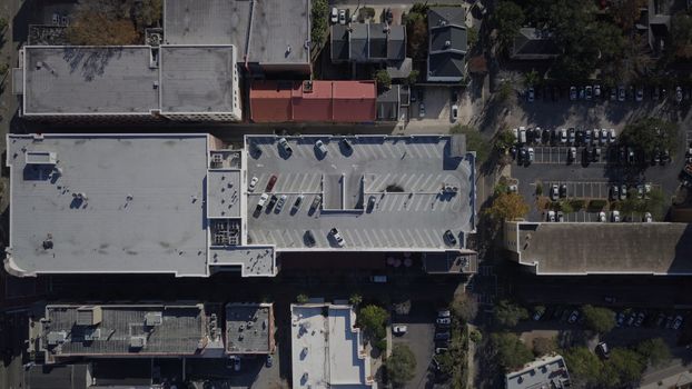 A detailed aerial view of a cityscape with buildings and a parking garage.
