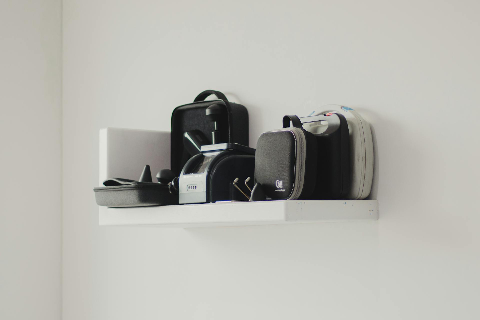 A minimalist white shelf displaying various storage containers and tools, highlighting organization.