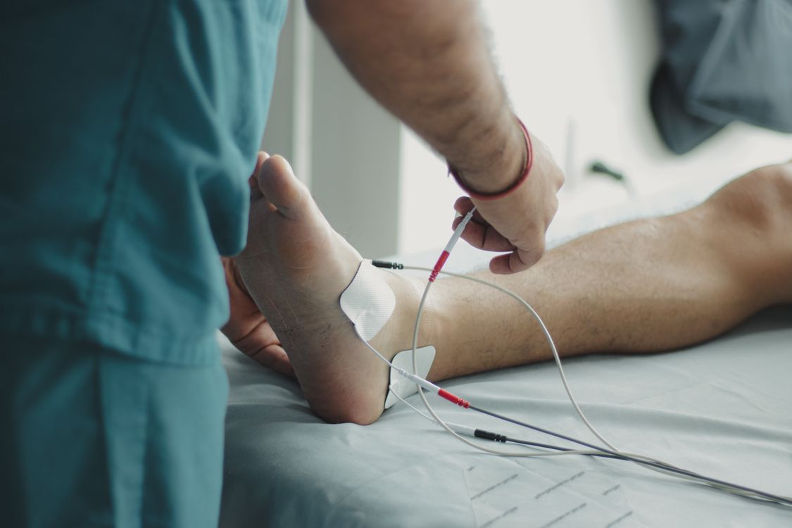 Atendimento de fisioterapia com aplicação de recurso terapêutico no tornozelo de paciente