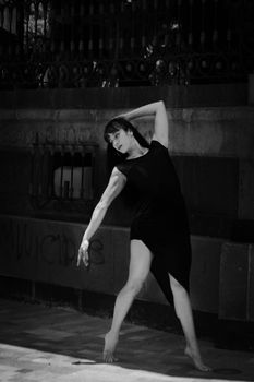 Ballerina poses gracefully against a background in monochrome.