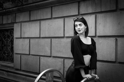Free Stylish woman posing confidently against an urban wall in black and white. Stock Photo