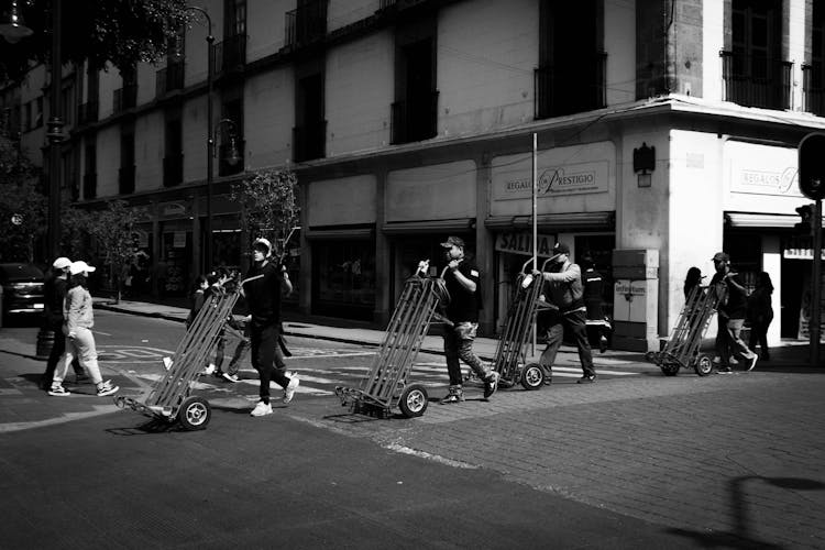 Men Pushing Trolley While Crossing The Road