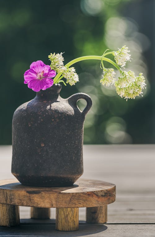 Purple and White Flowers in Black Ceramic Vase