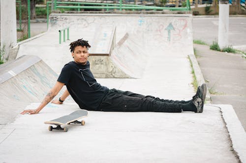 A Man in Black Shirt Sitting at the Skate Park