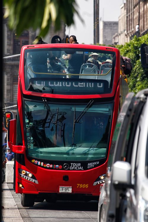 Free A vibrant red double-decker bus offers a scenic tour of Mexico City streets on a sunny day. Stock Photo