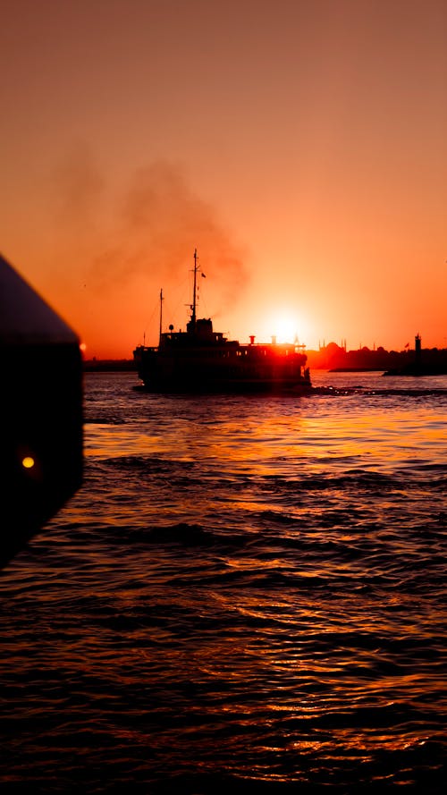 Silhouette of Ship on Sea During Sunset