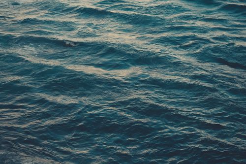 Free Peaceful ocean waves under a sunset sky, capturing tranquility and beauty. Stock Photo
