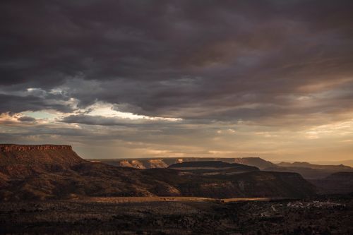 Free Expansive view of mountains under dramatic sky at twilight, showcasing nature's raw beauty. Stock Photo