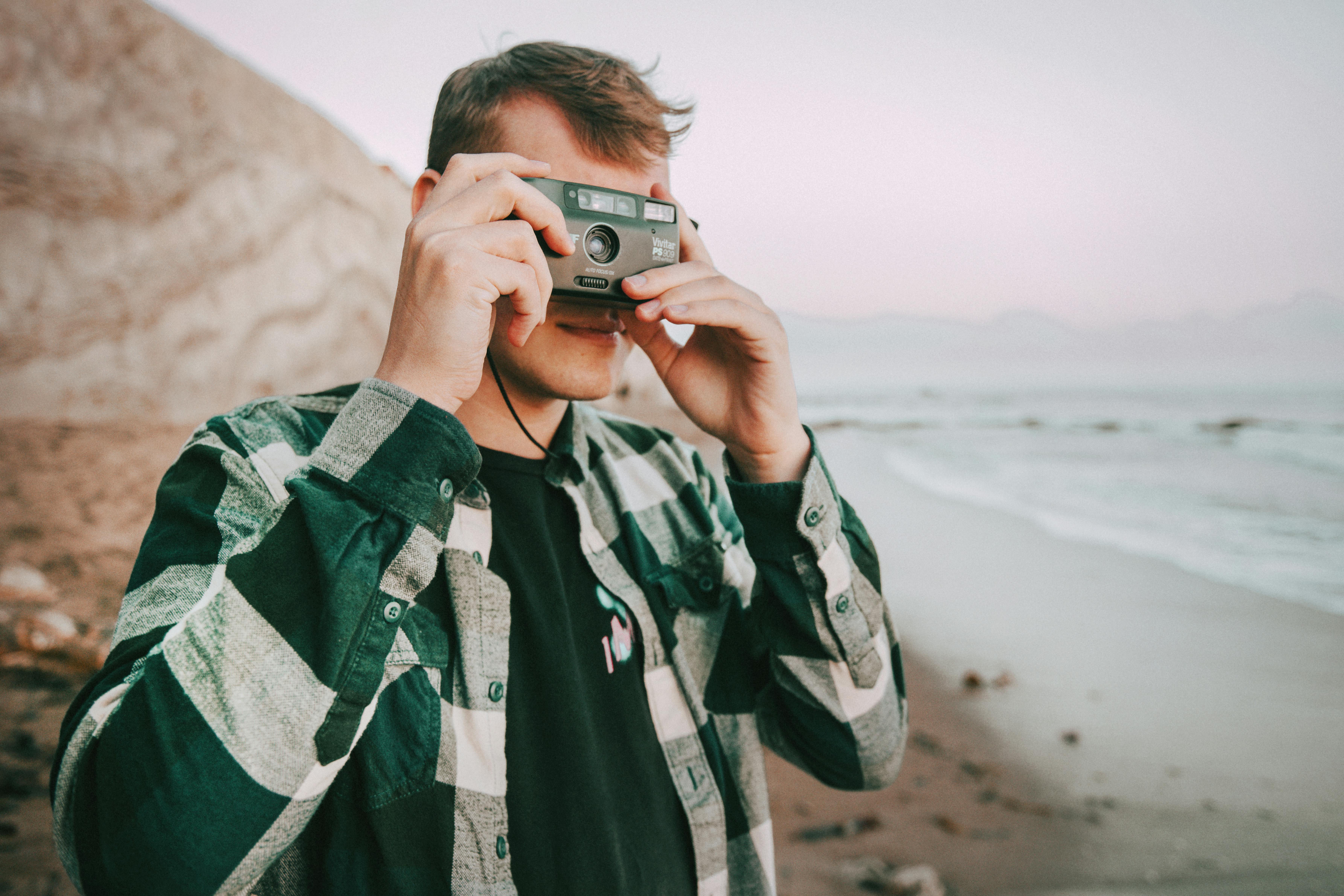 portrait of a man taking a picture with an analog camera