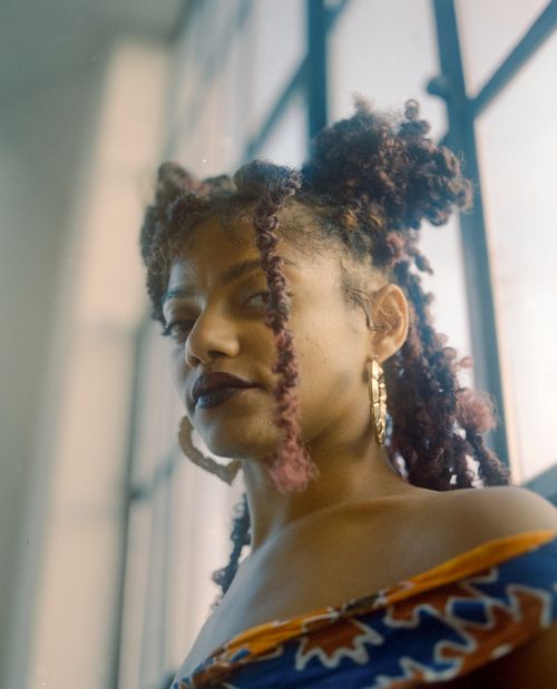 Free Elegant portrait of a stylish woman by a window in Philadelphia. Stock Photo